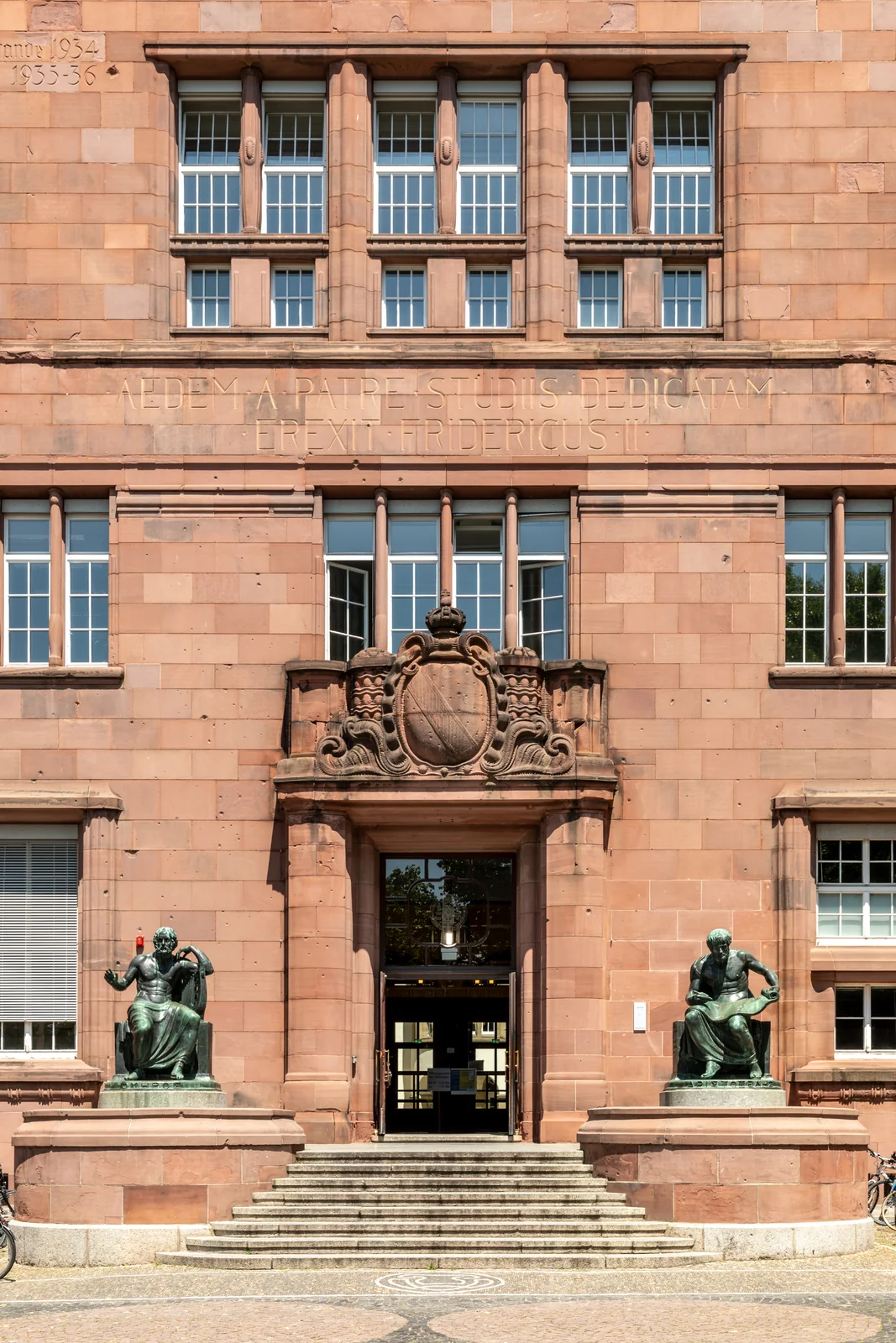 Eingang des Kollegiengebäudes I der Albert-Ludwigs-Universität Freiburg mit Bronzeskulpturen von Homer und Aristoteles. Hauptgebäude, in dem Hayek 1962 bis 1968 lehrte.